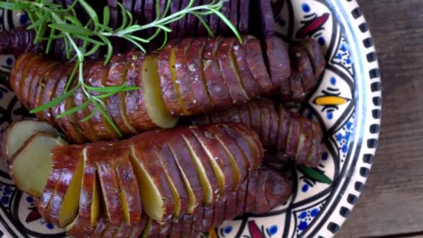 La batata - los tubérculos de batata cocidos en la cacerola. Frito y al horno con especias y sal. Corte en trozos y rebanadas. Comida saludable vista superior de cerca. Comida de papa en un plato sobre una mesa de madera — Vídeo de stock