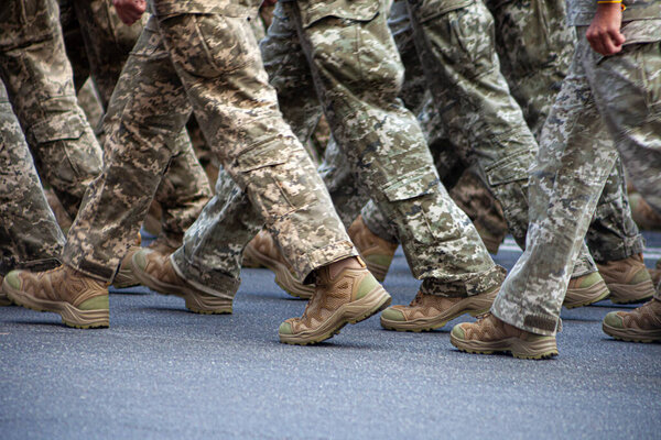Современная военная обувь на солдатах. На параде марширует солдат в форме. Люди в толпе. Сапоги на ногах.