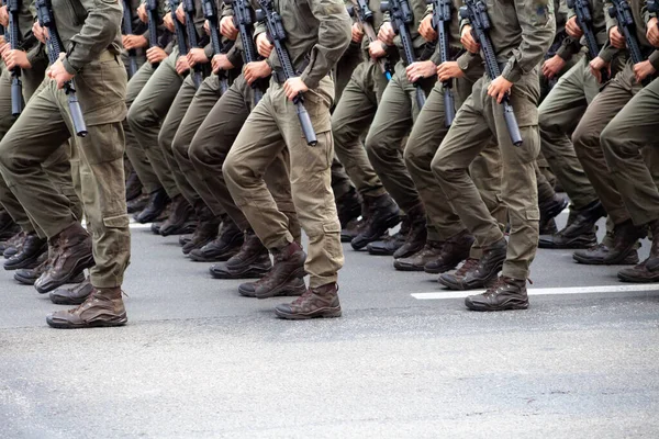 Calçado militar moderno em soldados. Um soldado de uniforme está a marchar no desfile. Pessoas na multidão. Botas no pé. — Fotografia de Stock