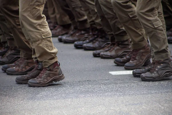 Modern katonai lábbeli katonákon. Egy egyenruhás katona menetel a felvonuláson. Emberek a tömegben. Csizma a lábon. — Stock Fotó