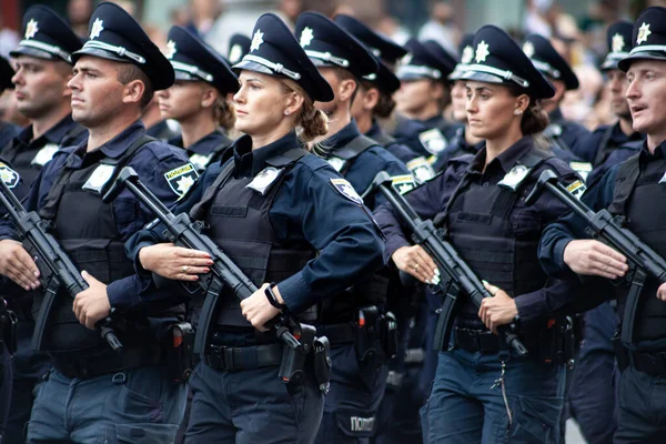 Ukraine, Kyiv - August 18, 2021: Selective focus. Ukrainian policeman with a machine gun. A man and a woman in uniform. The police are marching in the parade. Automatic rifle. — Stock Photo, Image