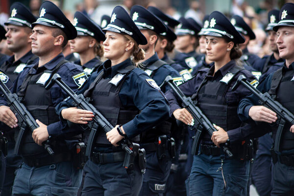 Ukraine, Kyiv - August 18, 2021: Selective focus. Ukrainian policeman with a machine gun. A man and a woman in uniform. The police are marching in the parade. Automatic rifle.