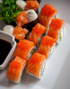 Somon suşi seti. Suşi Philadelphia 'yı kırmızı balıklı, somonlu, kırmızı havyarlı. Masaj havyarının altında yumuşak avokado ve krem peynirle yuvarlan. Klasik suşi. Gıda arkaplanı.