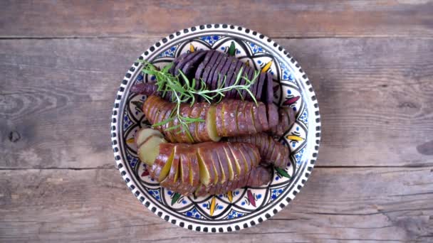 サツマイモ-パンで調理されたサツマイモの塊茎。スパイスと塩で揚げ、焼き.部分とスライスにカットします。健康的な食品のクローズアップトップビュー。木のテーブルの上のプレートにジャガイモの食事. — ストック動画