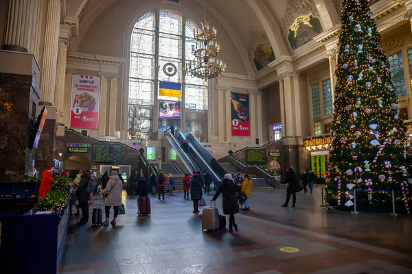 Ukraine, Kyiv - January 7, 2022: railway station building inside. Hall with a christmas tree, escalator and people with suitcases are traveling and waiting for their train. Travelers at the train — ストック写真
