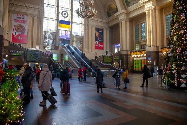 Ukrayna, Kyiv - 7 Ocak 2022: içerideki tren istasyonu binası. Bir Noel ağacı, yürüyen merdiven ve bavullu insanlar seyahat ediyor ve trenlerini bekliyorlar. Trende gezginler — Stok fotoğraf