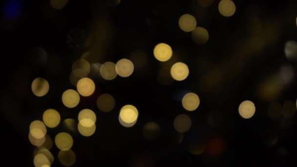 ガーランドのライトのボケ。焦点をぼかした。ガーランドが点滅している。夜の街の灯。クリスマス気分. — ストック動画