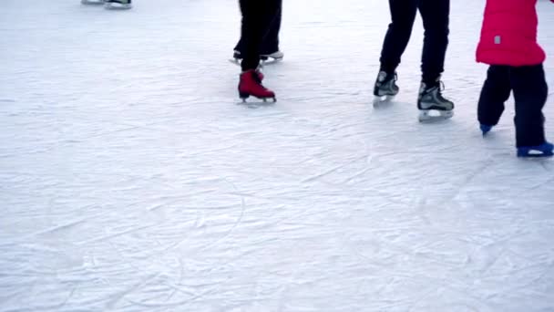 Skridskobana på vintern. Folk åker skridskor. Skridskor rider på is. Skridskoåkning är en vinter sport och underhållning. Kvinnor, barn, män ben går. — Stockvideo