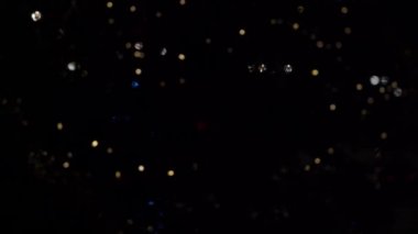 Bokeh dolusu çelenk. Bulanık yumuşak odak. Çelenk yanıp sönüyor. Gece şehir ışıkları. Noel havası.