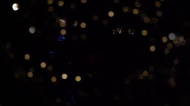 Bokeh dolusu çelenk. Bulanık yumuşak odak. Çelenk yanıp sönüyor. Gece şehir ışıkları. Noel havası.