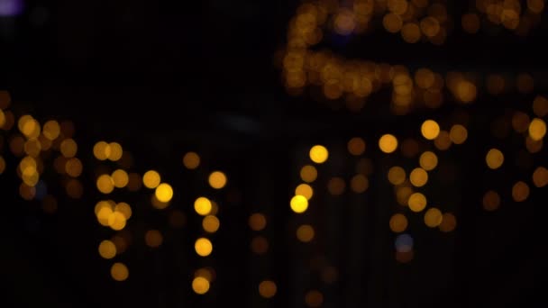 ガーランドのライトのボケ。焦点をぼかした。ガーランドが点滅している。夜の街の灯。クリスマス気分. — ストック動画