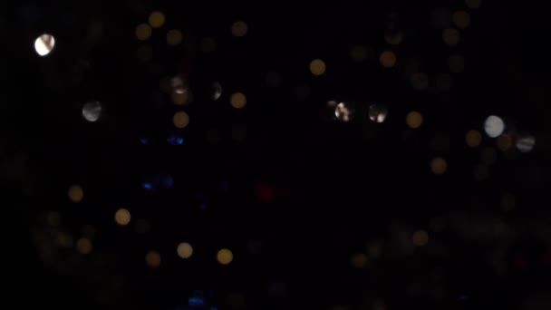 Bokeh of lights of garlands. Blurred soft focus. The garland is flashing. City lights at night. Christmas mood. — Stockvideo