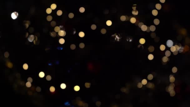 Bokeh of lights of garlands. Blurred soft focus. The garland is flashing. City lights at night. Christmas mood. — Wideo stockowe