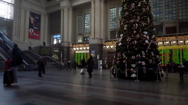 Ucrania, Kiev - 7 de enero de 2022: Árbol de Navidad en la estación de tren. Hall con escaleras mecánicas y personas con maletas están viajando y esperando su tren. Salida y llegada de viajeros. — Vídeos de Stock