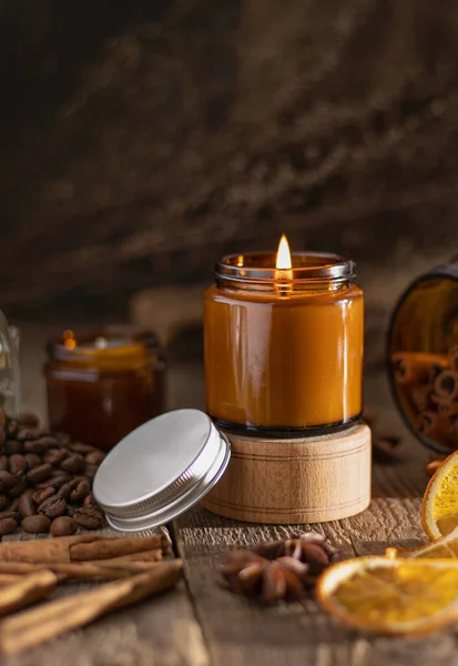 Doftljus i en glasburk. Kaffedoft. Stjärnanis, kanelstänger, torkad apelsin. Fortfarande liv. Kaffebönor. Bruna burkar med ljus. Aromaterapi — Stockfoto