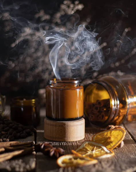 Cam kavanozdaki kokulu mum. Kahve aromalı. Yıldız anason, tarçın çubukları, kurutulmuş portakal. Durgun hayat. Kahve çekirdeği. Mumlu kahverengi kavanozlar. Aromaterapi