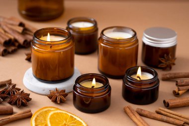 Beyaz arka planda cam kavanozlarda farklı aroma mumları. Kokulu el yapımı mum. Soya mumları kavanozda yanıyor. Balmumu ve parafin kavanozda.