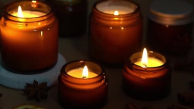 Kahverengi cam kavanozlarda Aroma mumları. Mum karanlıkta yanar. Aromaterapi, romantizm ve spa 'da rahatlama. Kokulu ve soya mumları geceleri yanar. Kavanozda balmumu ve parafin.