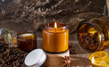 Cam kavanozdaki kokulu mum. Kahve aromalı. Yıldız anason, tarçın çubukları, kurutulmuş portakal. Durgun hayat. Kahve çekirdeği. Mumlu kahverengi kavanozlar. Aromaterapi