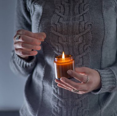 Elinde bir soya mumu tut ve yak. Kavanozda mum. Aromatheramia. Aroma mumu.