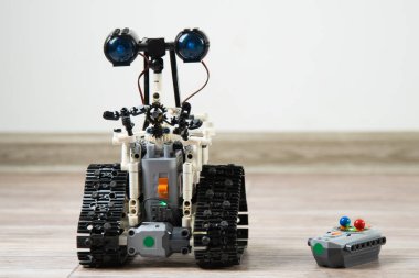 Kontrol panelindeki çocuk tasarımcıdaki robot. Eğitici oyuncaklar. Uzaktan kumandalı bir robot yerde geziyor. Robotlar iş başında. İnşaatçının robotu