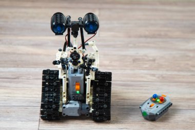 Kontrol panelindeki çocuk tasarımcıdaki robot. Eğitici oyuncaklar. Uzaktan kumandalı bir robot yerde geziyor. Robotlar iş başında. İnşaatçının robotu