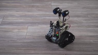 Kontrol panelindeki çocuk tasarımcıdaki robot. Eğitici oyuncaklar. Uzaktan kumandalı bir robot yerde geziyor. Robotlar iş başında