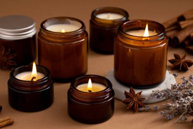 Beyaz arka planda cam kavanozlarda farklı aroma mumları. Kokulu el yapımı mum. Soya mumları kavanozda yanıyor. Balmumu ve parafin kavanozda.