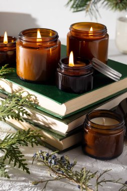 Beyaz arka planda cam kavanozlarda farklı aroma mumları. Kokulu el yapımı mum. Soya mumları kavanozda yanıyor. Balmumu ve parafin kavanozda.