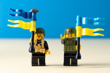 Ukrayna bayraklı küçük lego adamlar. Mavi bayrak taşıyan minyatür bir oyuncak adam. Ukrayna halkının desteği için. Ukrayna, Kyiv - 20 Mart 2022