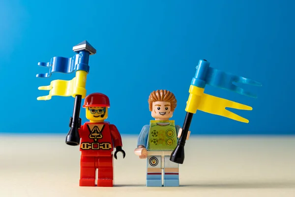 ウクライナの旗を持つレゴの小さな男。青い旗を持ったミニフィギュアのおもちゃの男。ウクライナの人々の支援。ウクライナ,キエフ- 2022年3月20日 — ストック写真
