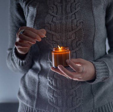 Elinde bir soya mumu tut ve yak. Kavanozda mum. Aromatheramia. Aroma mumu.