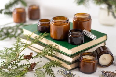 Beyaz arka planda cam kavanozlarda farklı aroma mumları. Kokulu el yapımı mum. Soya mumları kavanozda yanıyor. Balmumu ve parafin kavanozda.