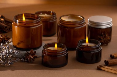 Beyaz arka planda cam kavanozlarda farklı aroma mumları. Kokulu el yapımı mum. Soya mumları kavanozda yanıyor. Balmumu ve parafin kavanozda.