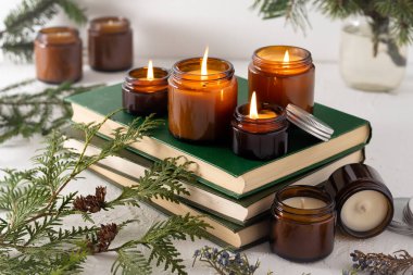 Beyaz arka planda cam kavanozlarda farklı aroma mumları. Kokulu el yapımı mum. Soya mumları kavanozda yanıyor. Balmumu ve parafin kavanozda.