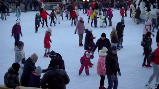 Pista de patinaje sobre hielo en invierno. La gente patina. Patines montados sobre hielo. El patinaje sobre hielo es un deporte de invierno y entretenimiento. Las mujeres, los niños, las piernas de hombre van. — Vídeo de stock