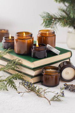 Beyaz arka planda cam kavanozlarda farklı aroma mumları. Kokulu el yapımı mum. Soya mumları kavanozda yanıyor. Balmumu ve parafin kavanozda.