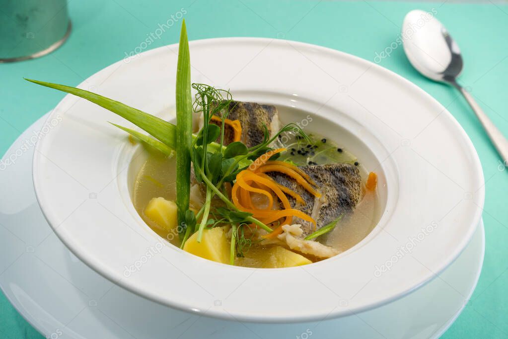 Ukha - fish soup from Sudak. Plate with first course soup with potatoes, carrots, onions and fish broth.