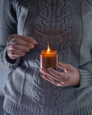 Elinde bir soya mumu tut ve yak. Kavanozda mum. Aromatheramia. Aroma mumu.