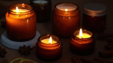 Kahverengi cam kavanozlarda Aroma mumları. Mum karanlıkta yanar. Aromaterapi, romantizm ve spa 'da rahatlama. Kokulu ve soya mumları geceleri yanar. Kavanozda balmumu ve parafin.