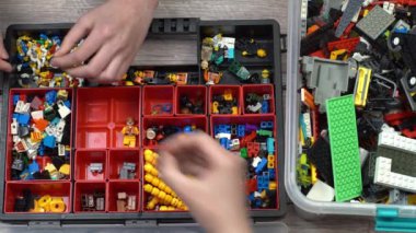 Oyuncak üreticisi çocuklar. Bir sürü renkli detay. Oyun ve inşaat için bloklar ve tuğlalar. Eğitici oyuncak. Lego figürleri. Sıralama ve depolama. Çal.