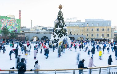 Kışın buz pateni pistinde. İnsanlar paten kayıyor. Patenler buzda kayar. Buz pateni kış sporu ve eğlencedir. Kadınlar, çocuklar, erkek bacakları....