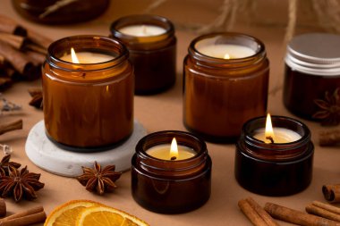 Beyaz arka planda cam kavanozlarda farklı aroma mumları. Kokulu el yapımı mum. Soya mumları kavanozda yanıyor. Balmumu ve parafin kavanozda.