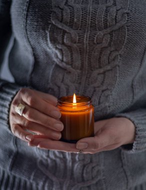 Elinde bir soya mumu tut ve yak. Kavanozda mum. Aromatheramia. Aroma mumu.