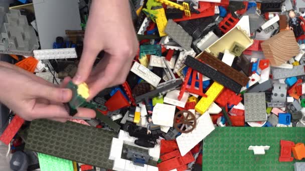 Lego vagyok. Gyerekjáték-tervező. Sok színes részlet van benne. Blokkok és téglák a játékhoz és építéshez. Oktatási játék. Lego figurák. Válogatás és tárolás. Játssz! Kijev, Ukrajna - március 30, 2022. — Stock videók
