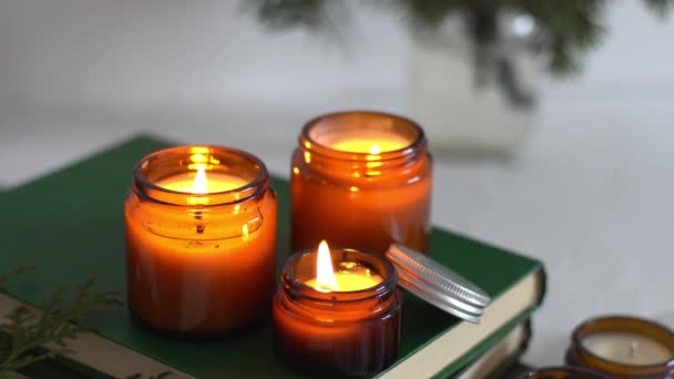 Una serie di candele aromatiche diverse in vasi di vetro su uno sfondo bianco. Candela profumata fatta a mano. Candele di soia stanno bruciando in un barattolo. Cera e paraffina in un barattolo — Video Stock