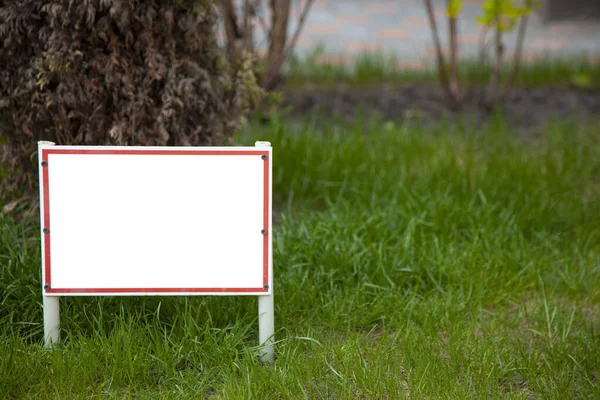 Pointer sign on the lawn with green grass. Banner layout with place for the text dog walking is prohibited , do not walk on the lawn, it is dangerous. Information board layout. Mockup Royalty Free Stock Images