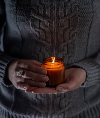 Elinde bir soya mumu tut ve yak. Kavanozda mum. Aromatheramia. Aroma mumu.
