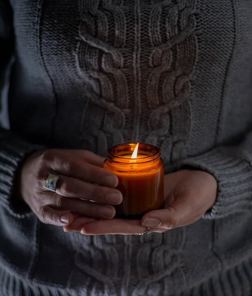 Elinde bir soya mumu tut ve yak. Kavanozda mum. Aromatheramia. Aroma mumu.