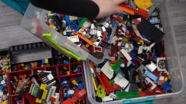 Lego. Constructeur de jouets pour enfants. Beaucoup de détails colorés. Blocs et briques pour jouer et construire. Jouet éducatif. Des chiffres de Lego. Tri et stockage. Joue. Kiev, Ukraine - 30 mars 2022. — Video